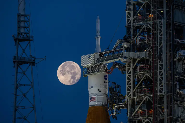 A full moon was visible behind the Artemis I SLS (Space Launch System) rocket and Orion spacecraft at Launch Complex 39B at NASA’s Kennedy Space Center in Florida on June 14, 2022. The first in an increasingly complex series of missions, Artemis I tested SLS and Orion as an integrated system prior to crewed flights to the Moon.　Image Credit : NASA